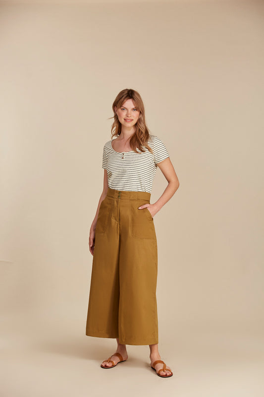 Woman wears wide legged khaki organic cotton trousers and stripped top