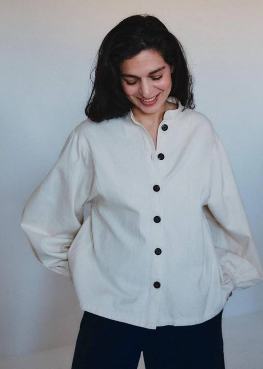 Woman wearing an oversized linen shirt with black buttons