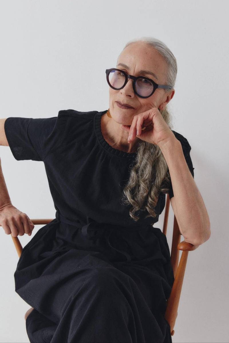 Woman wearing an elegant black cotton dress sitting on a chair