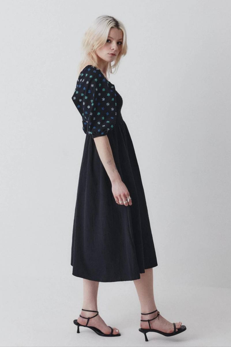Side view of a woman wearing a floral print midi dress with puff sleeves